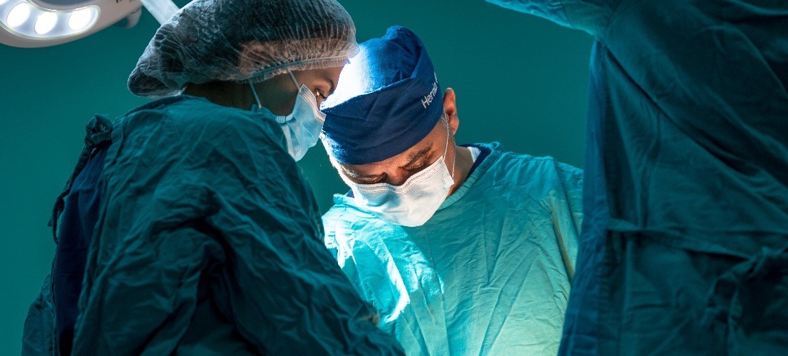 Healthcare workers performing a surgical procedure.