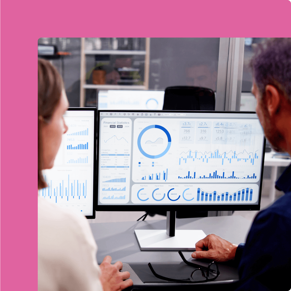 Two market researchers analyzing financial data across various charts.